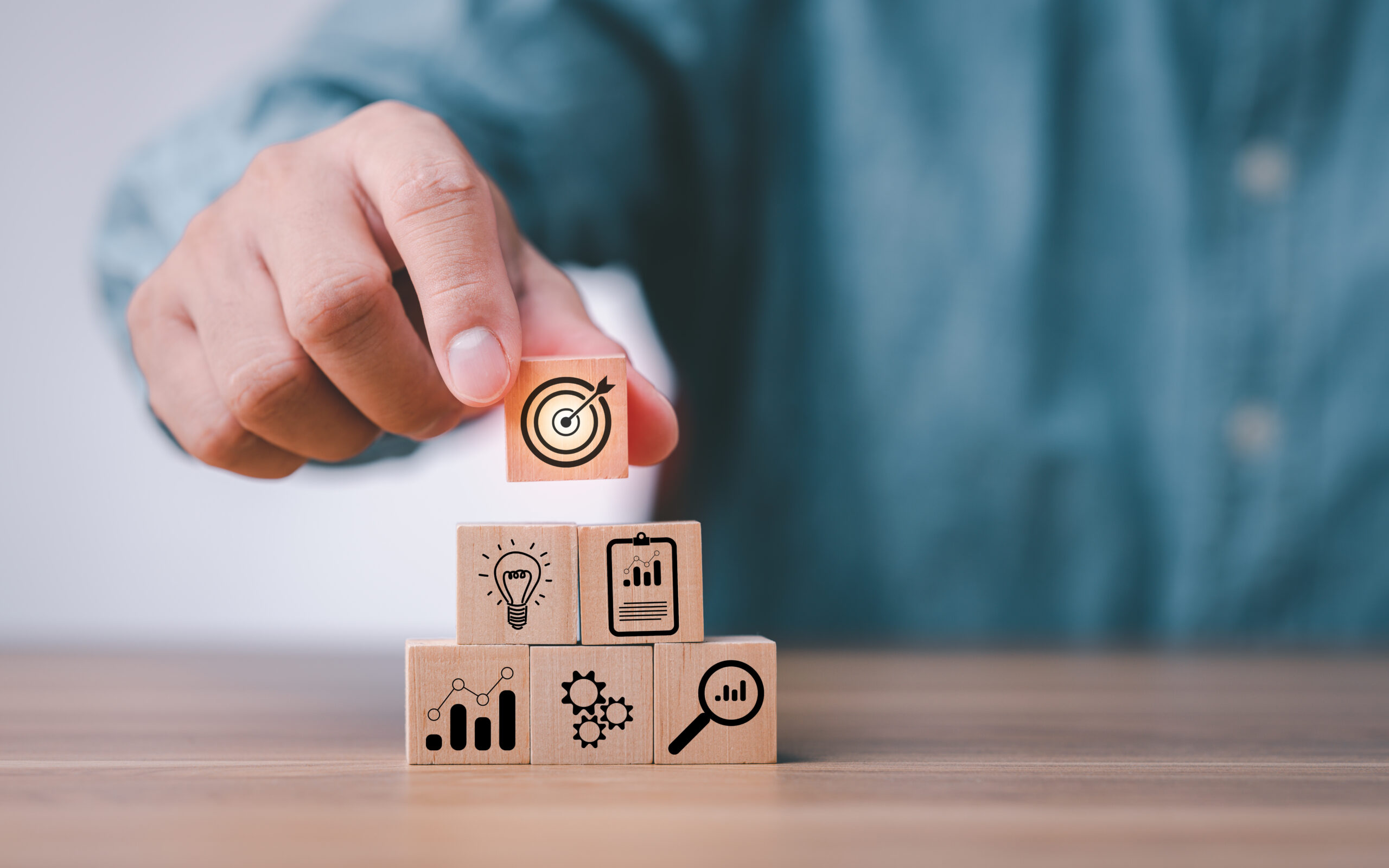 idea of goal and target. hand stack woods block step on table with icon business strategy and Action plan. business development concept.copy space.